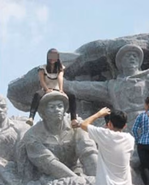 Gây bức xúc hơn là cô gái ngồi lên đầu bức tượng chiến sĩ giải phóng và chụp ảnh. Đó là hành động khó ai chấp nhận được.