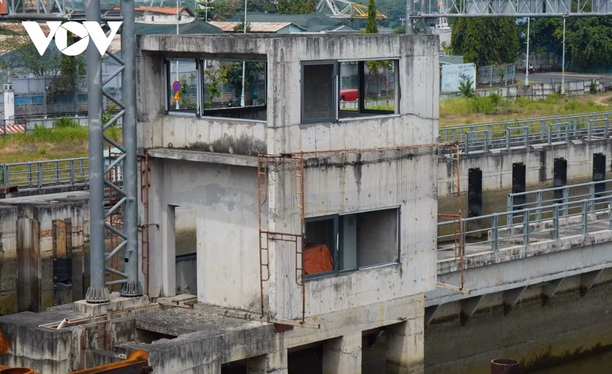 Theo quan sát, công trường cống ngăn triều Tân Thuận không có công nhân làm việc, nhiều hạng mục còn dở dang, khu vực hệ thống nhà điều hành có nhiều cây cối phủ kín lối đi