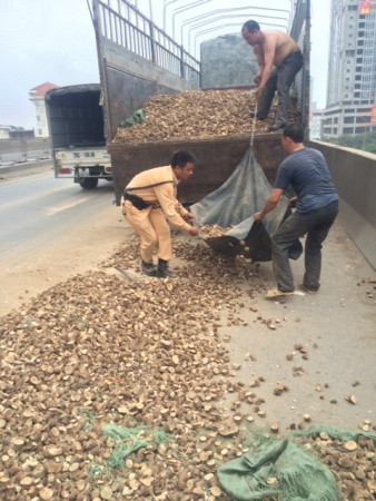 Quần áo lấm bẩn, thấm mồ hôi nhưng các chiến sĩ vẫn không ngừng giúp đỡ hai tài xế vận chuyển số sắn khô bị rơi vãi lên xe.