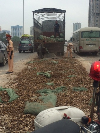 Một lượng sắn khô rất lớn đổ ra đường nhưng các chiến sĩ vẫn vừa điều khiển giao thông vừa rất cần mẫn giúp đỡ.