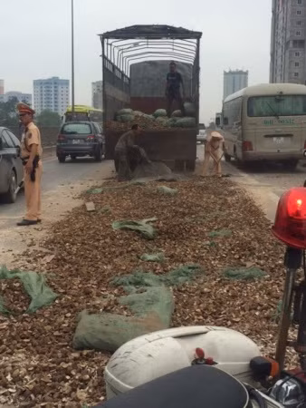 Một lượng sắn khô rất lớn đổ ra đường nhưng các chiến sĩ vẫn vừa điều khiển giao thông vừa rất cần mẫn giúp đỡ.