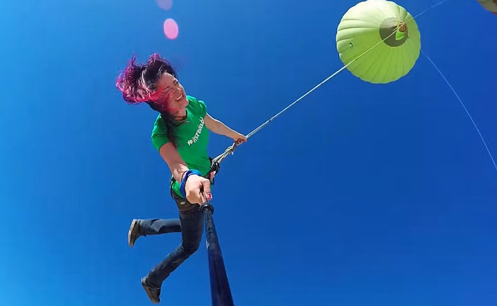 Họ sử dụng khinh khí cầu để làm bục nhảy và lao ra ngoài không trung với những sợi dây thừng bảo hộ buộc quanh người cùng với gậy tự sướng để chụp ảnh.