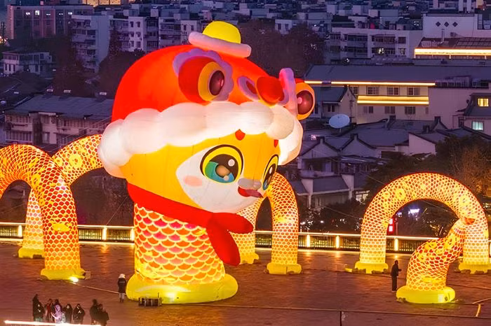 Linh vật rắn đầu đội nón lân, cổ quấn khăn quàng đỏ như đang bơi ra từ bức tường thành Nam Kinh (Giang Tô) cổ kính. Ảnh: Weibo