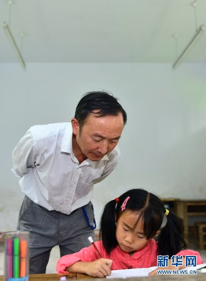 Thầy giáo đang tận tình hướng dẫn Liu cách thức làm bài tập về nhà.