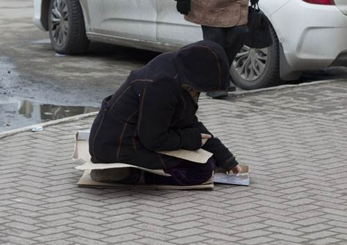 Người phụ nữ đang đếm những đồng xu mà cô được người đi đường bố thí.