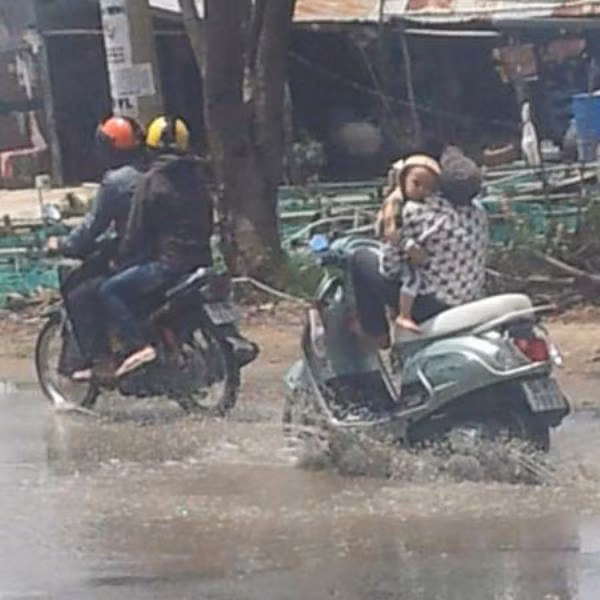 Vừa ôm con, vừa lái xe.