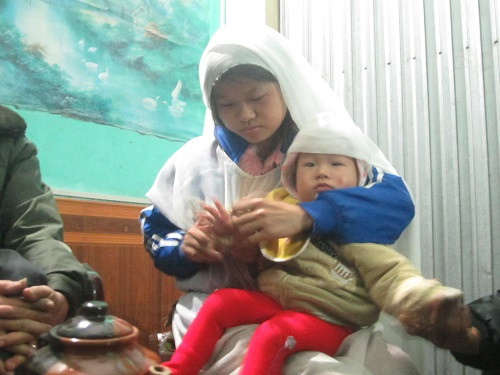 Người vợ trẻ và con thơ của nạn nhân Nguyễn Bá Thuấn.