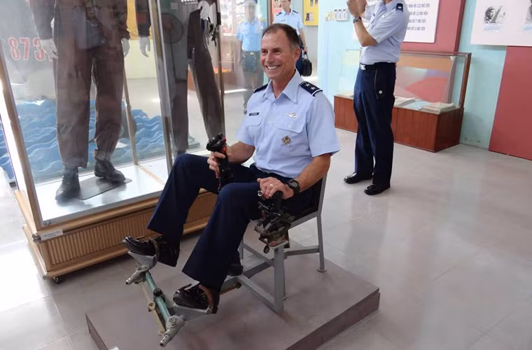 Một sĩ quan Mỹ ngồi thử thiết bị tập lái máy bay đơn giản do các cán bộ, giảng viên trường Sĩ quan Không quân tự chế.