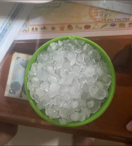 Người dân nhặt hạt đá sau khi trận dông lốc, mưa đá kết thúc.