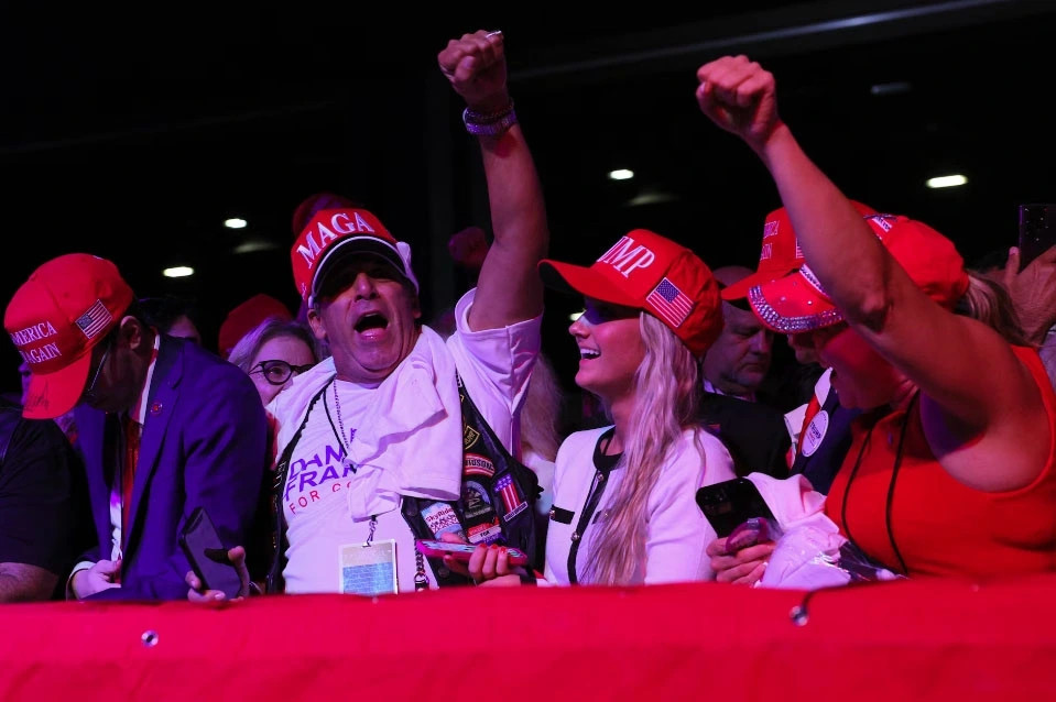Các cử tri ủng hộ ông Trump đội mũ in dòng chữ “MAGA” và “Trump” giơ nắm tay thể hiện quyết tâm chiến thắng tại Florida.