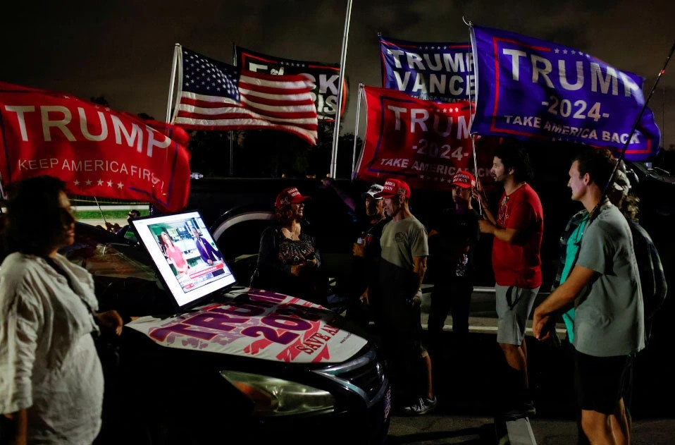 Những người ủng hộ ông Trump theo dõi tin tức bầu cử trên màn hình kết nối với ô tô vào Ngày bầu cử trong không khí sôi động, gần Mar-a-Lago, tại Palm Beach, Florida.