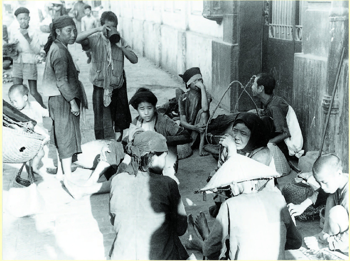 Sách tập trung khắc họa một "đặc sản" không thể trộn lẫn của Hà Nội: Hàng rong và tiếng rao. Trong ảnh, những người bán hàng rong ngồi nghỉ trên vỉa hè gần chợ Đồng Xuân.