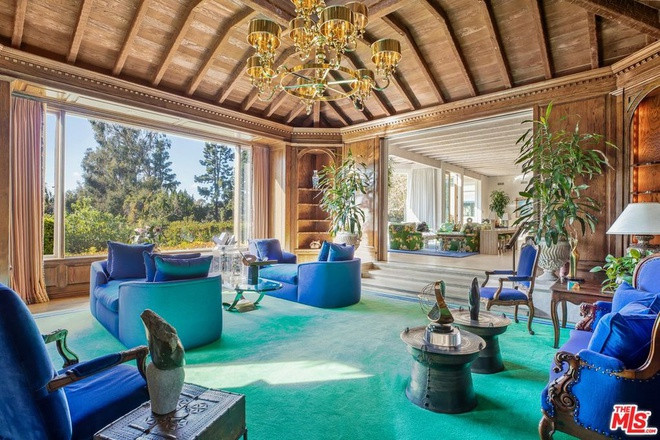 Phòng đọc sách rộng lớn, được ốp gỗ cứng. Một bức tường kính đem lại ánh sáng tự nhiên.