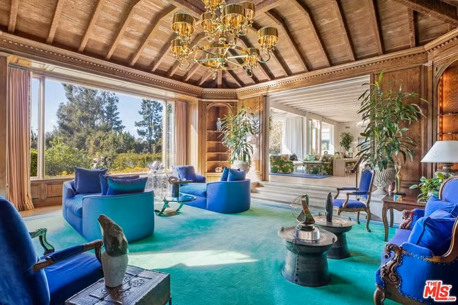 Phòng đọc sách rộng lớn, được ốp gỗ cứng. Một bức tường kính đem lại ánh sáng tự nhiên.