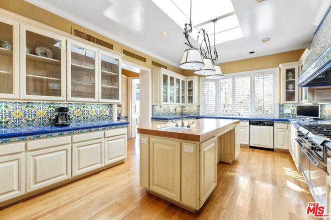 Nhà bếp sang trọng được lát sàn gỗ cứng và gạch ốp tường sặc sỡ. Khu vực này được trang bị đầy đủ công cụ nấu nướng cao cấp.