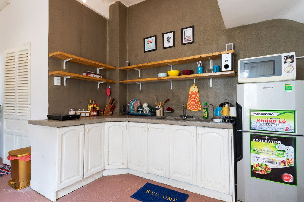 Phòng bếp được bố trí các kệ gỗ trên tường xám mang đến sự nhã nhặn nhưng không kém phần nổi bật từ các đồ dùng hoạt tiết sáng màu.