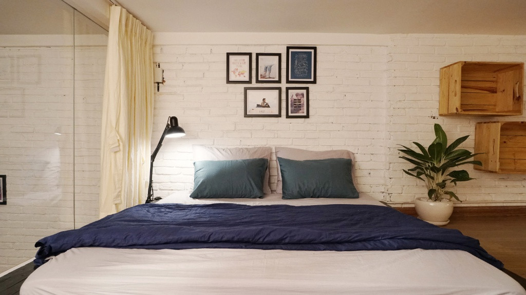 Một phòng ngủ đặc biệt khác nằm trên gác lửng được ngăn cách bằng tường kính với gam màu trắng - xanh thống nhất với cả căn nhà.