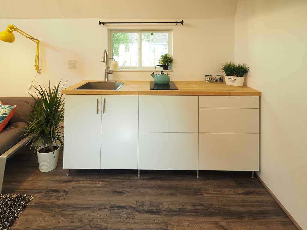 Không gian bếp nhỏ gọn và đơn giản những vẫn có đầy đủ bồn rửa chén, lò điện tử để có thể chế biến một bữa ăn hoàn chỉnh cho gia đình với cửa sổ hướng ra vườn tránh vương mùi trong nhà.