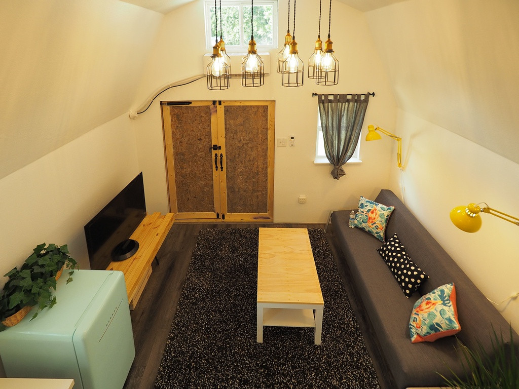 Màu trắng được lựa chọn làm màu chủ đạo với nhiều cửa sổ mang đến ánh sáng cho căn nhà và tạo cảm giác không gian rộng hơn. Bên ngoài, màu xanh đậm được lựa chọn để hòa mình vào thiên nhiên trong khi cửa chính được sơn màu vàng của hoa hướng dương.