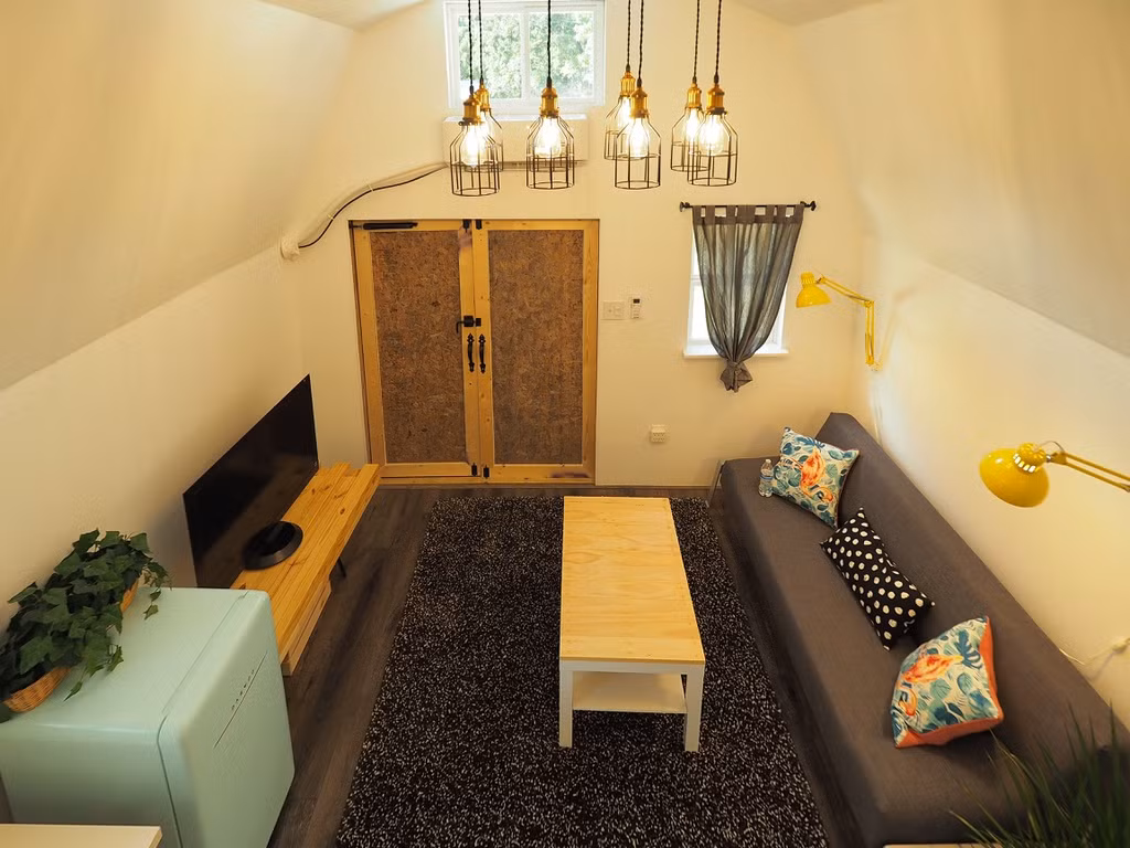 Màu trắng được lựa chọn làm màu chủ đạo với nhiều cửa sổ mang đến ánh sáng cho căn nhà và tạo cảm giác không gian rộng hơn. Bên ngoài, màu xanh đậm được lựa chọn để hòa mình vào thiên nhiên trong khi cửa chính được sơn màu vàng của hoa hướng dương.