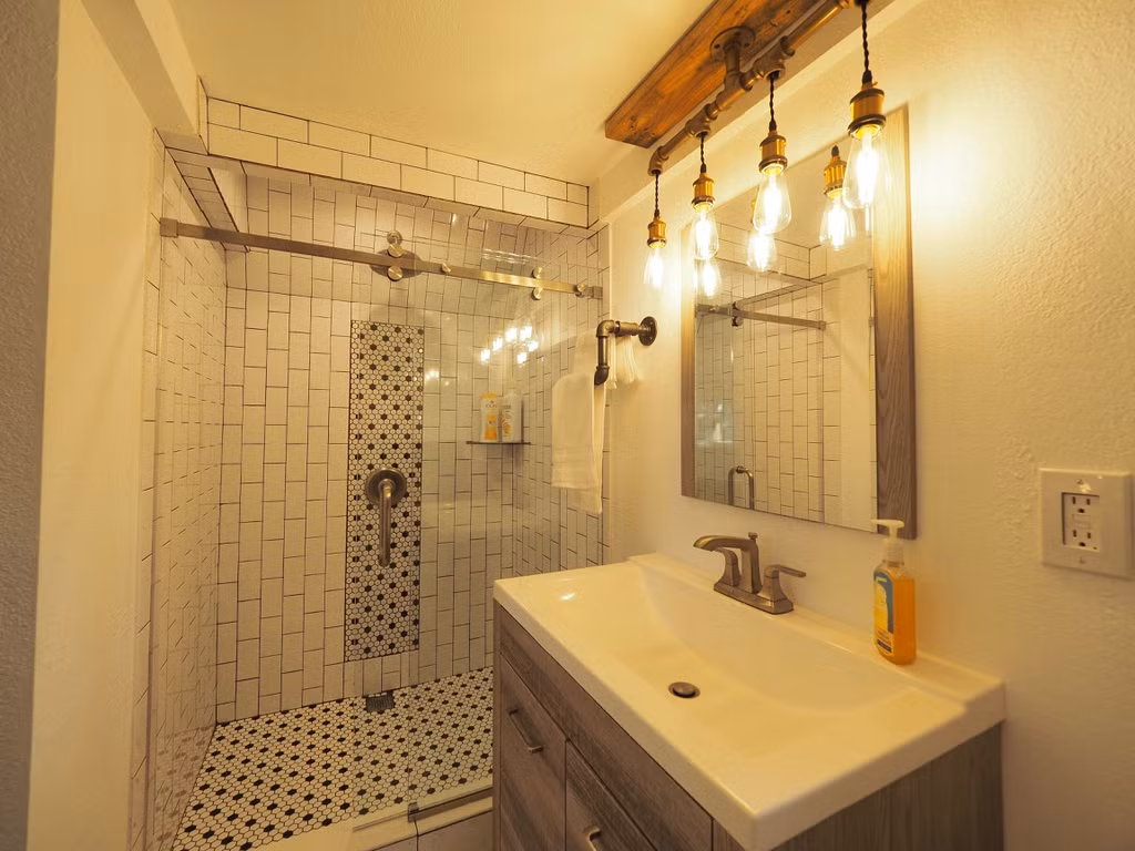 Diện tích nhỏ nhưng một phần không gian lớn vẫn được dành cho phòng tắm full size với vòi tắm dạng rain shower cùng cửa kính.