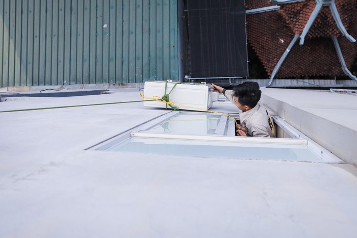 Cục nóng được tôi buộc dây, một dây để tôi giữ tại cửa sổ tầng 4, một dây để đồng nghiệp kéo từ tầng 5 sang vị trí cần đặt. Đây là giải pháp tình thế khi tôi đang ở độ cao gần 20 m so với mặt đất.