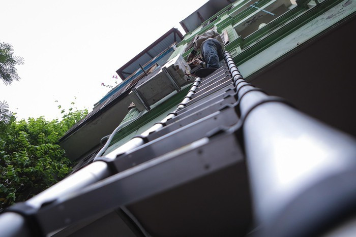 Với khách hàng đầu tiên, tôi cần lắp đặt cục nóng trên tầng 2. Tôi dùng chiếc thang chuyên dụng leo lên vị trí ban công.