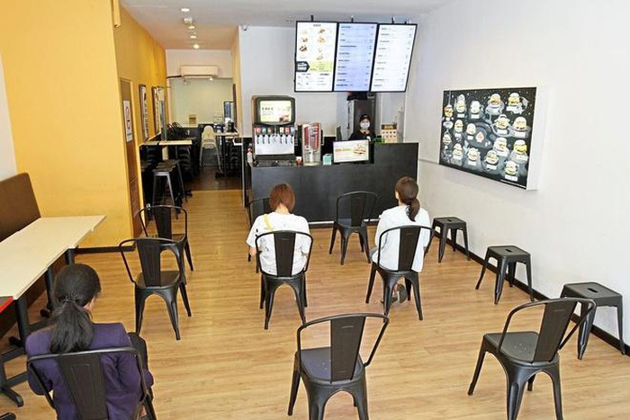 Một cửa hàng khác lại đặt ghế cách xa nhau cho khách hàng đến mua đồ. Ảnh: The Star.