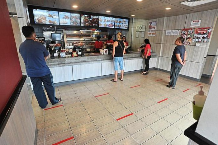 Những vạch đỏ quy định chỗ đứng của khách hàng tại một cửa hàng ở Labuan, Malaysia. Ảnh: The Star.