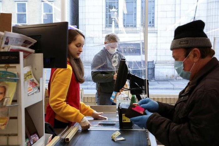 Một số cửa hàng tạp hóa sử dụng tấm nhựa để đảm bảo an toàn cho nhân viên thu ngân và khách hàng. Ảnh: Reuters.