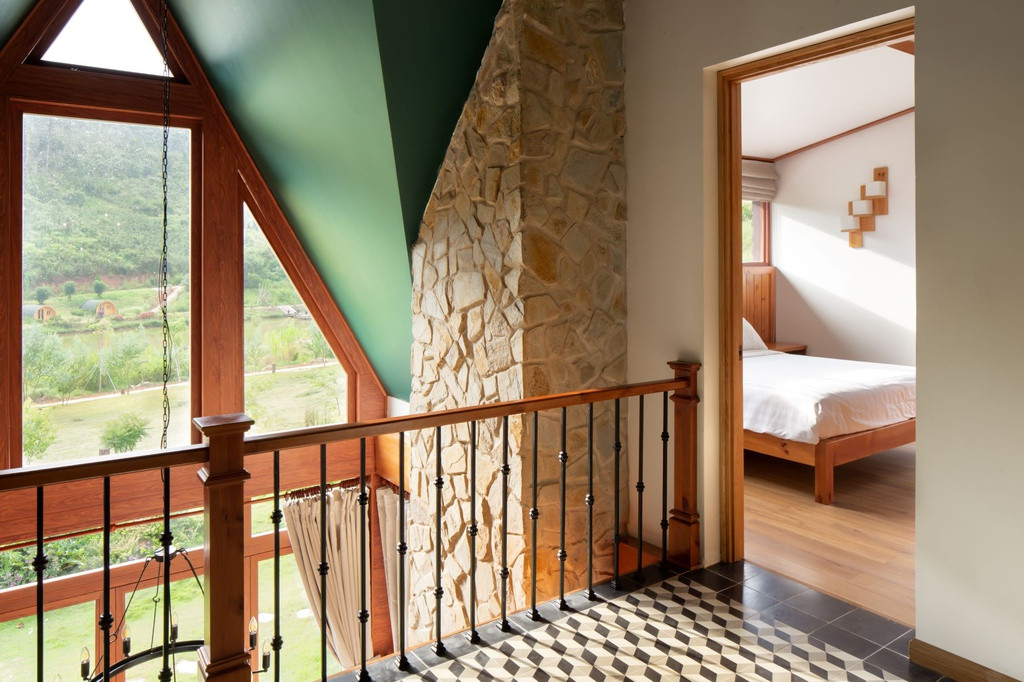 Kiến trúc sư sử dụng vật liệu sẵn có tại địa phương như gỗ thông, đá kết hợp với gạch bông mang lại cảm giác thân thiện. Phòng ngủ được thiết kế đơn giản, trang nhã với hệ cửa kính lớn.