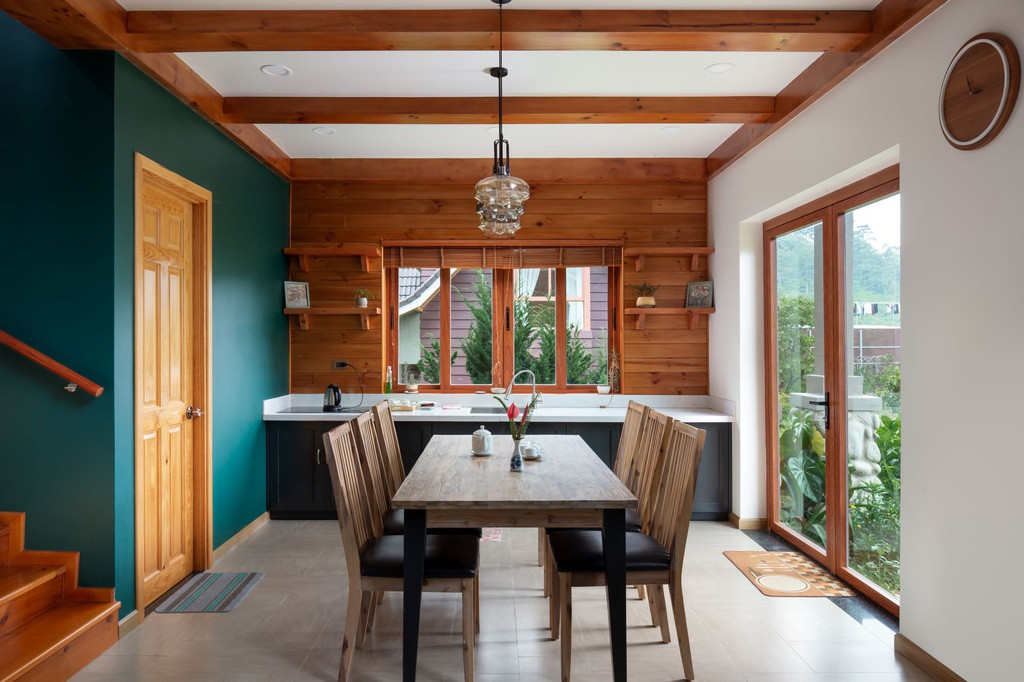 Không gian bếp và bàn ăn được thiết kế để đón tối đa ánh sáng tự nhiên, kết hợp chất liệu gỗ tạo cảm giác ấm cúng.