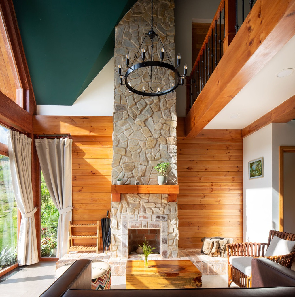 Phòng khách trần cao thông tầng và lò sưởi tạo nên một không gian sinh hoạt chung rộng rãi, tràn ngập ánh nắng vào ban ngay và ấm cúng khi đêm về.