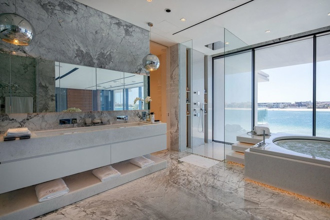 Phòng tắm lát đá cẩm thạch với bể sục jacuzzi.