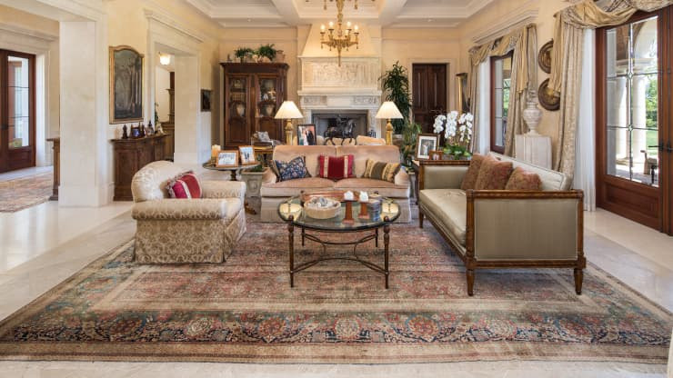 Phòng khách thoáng đãng, trang nhã, tràn ngập ánh sáng tự nhiên, nổi bật với một chiếc lò sưởi cầu kỳ.