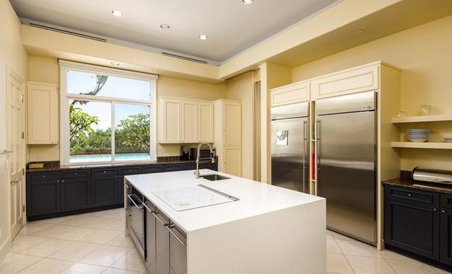 Nhà bếp sáng sủa, mang tông màu kem thanh lịch chủ đạo, được trang bị những công cụ nấu nướng hiện đại tích hợp trong các tủ gỗ khổng lồ