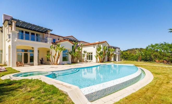 Hồ bơi, bồn tắm nước nóng ngoài trời được bao quanh bởi hàng cây xanh cao.