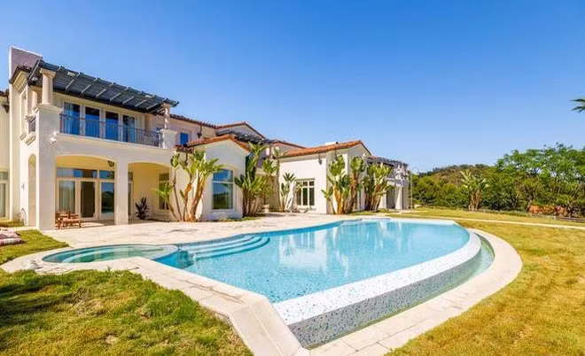 Hồ bơi, bồn tắm nước nóng ngoài trời được bao quanh bởi hàng cây xanh cao.