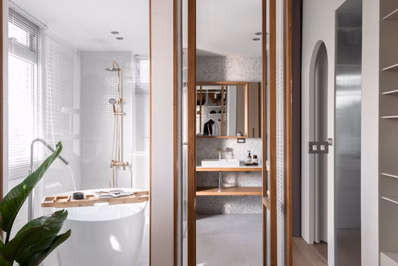 Cửa đôi khung gỗ kết nối khu vực thay đồ với phòng tắm riêng.