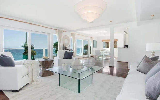 Phòng khách nằm liền kề nhà bếp với tông màu trắng chủ đạo, hòa quyện tinh tế cùng màu xanh của đại dương. Ảnh: Business Insider.