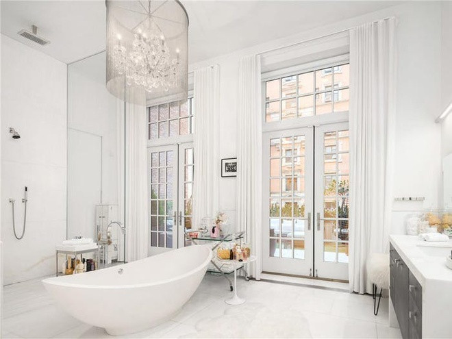 Phòng tắm lát đá cẩm thạch Ý, có cửa ra vào hướng ra sân thượng, bên trong có một bồn tắm lớn và vòi hoa sen. Ảnh: Business Insider.