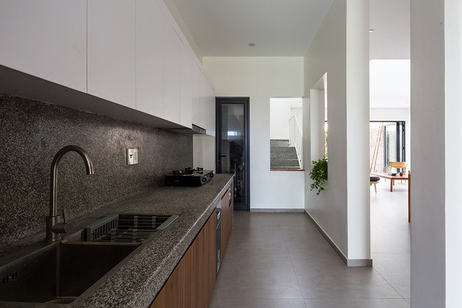 Tông màu xám trắng chủ đạo thêm điểm nhấn là màu gỗ tự nhiên cho căn bếp vẻ hiện đại.