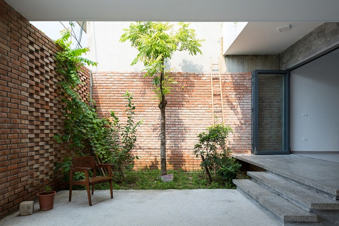 Khoảng sân trước nhà là bãi đậu xe và sân vườn cảnh quan. Trong khi toàn bộ tường trước được làm bằng gạch xếp.