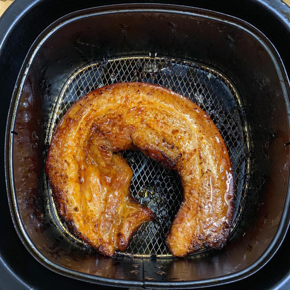  Thịt nướng ngũ vị: Thịt ba chỉ sau khi sơ chế, đem ướp với bột canh, ngũ vị hương, đường (hoặc mật ong), bột tỏi, bột hành, xì dầu, hạt tiêu, nước soda, dầu ăn và dầu hào. Trộn đều thịt với sốt ướp, bọc kỹ và cất ngăn mát tủ lạnh khoảng 2 tiếng. Khi nướng với nồi chiên không dầu, bạn gói miếng thịt vào giấy bạc, nướng 15 phút ở nhiệt độ 180 độ C. Sau đó gỡ giấy bạc, hạ nhiệt độ xuống 160 độ C, nướng 5 phút và lật mặt miếng thịt, nướng một lần nữa. Dùng phần nước ướp mà thịt tiết ra trộn, với mật ong và quết đều lên mặt thịt để có màu đẹp hơn.