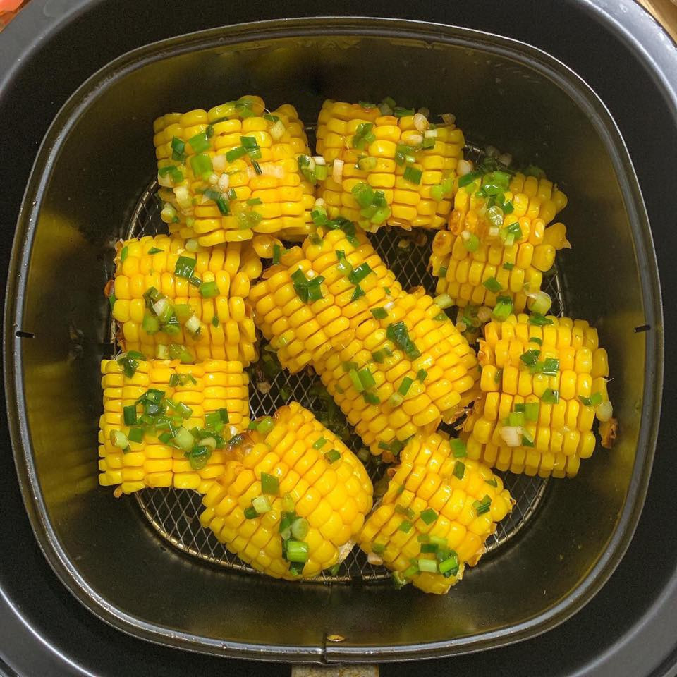  Ngô nướng bơ hành: Phi thơm tỏi băm, cho thêm bơ (hoặc dầu ăn), đợi dầu bơ thật sôi đổ hành lá, vào thêm bột canh hoặc bột nêm, một ít ớt bột (có thể thêm đường tùy khẩu vị). Trộn đều các nguyên liệu. Ngô có thể luộc chín để khi nướng nhanh hơn và không bị khô. Phết mỡ hành lên ngô và xếp lên vị nướng của nồi chiên không dầu, nướng trong khoảng 4-5 phút ở 160 độ C.