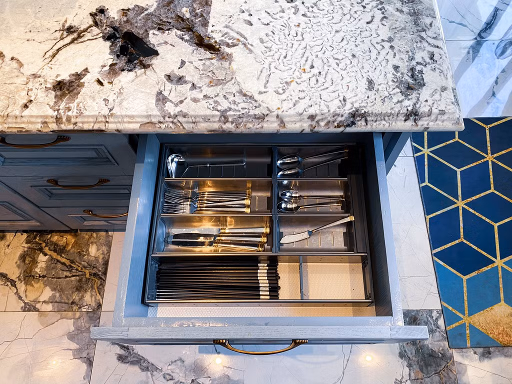 Căn bếp có sự sắp xếp rất khoa học. Các giá đỡ, ngăn chia công năng là bí mật làm nên sự ngăn nắp, logic. Kinh nghiệm được vợ ca sĩ chia sẻ là sau khi lấy kích thước để thi công các ngăn tủ phù hợp, cô sẽ lựa chọn mua các giá đỡ sau vì có thể tháo lắp được. Ngoài ra, những ngăn tủ không cần thiết, cô chỉ làm thanh ngang bằng gỗ để chia tủ nhưng vẫn tối ưu hóa không gian.