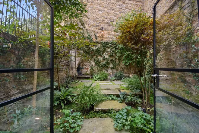 Phía sau phòng ăn có một khu vườn lớn, giúp tầng hầm vẫn có nắng và ngập trong không gian tự nhiên.