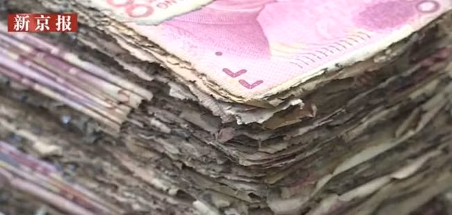 Nhân viên ngân hàng đã phải làm thêm giờ để kiểm tra các tờ tiền, 2 nhân viên ngồi tách các tờ tiền bị dính.