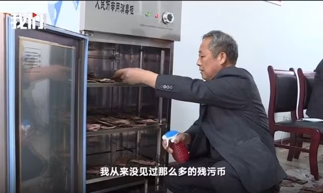 Một số tiền bị dính chặt, nhân viên phải dùng tay tách ra và dự kiến công việc này kéo dài nửa tháng trời.