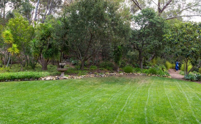 Không gian sân vườn rộng lớn, xanh mướt với bãi cỏ được cắt tỉa cẩn thận.